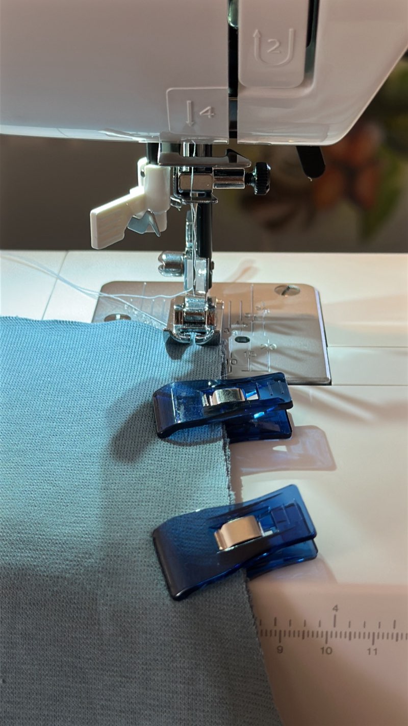 Sewing machine stitching the blue jersey